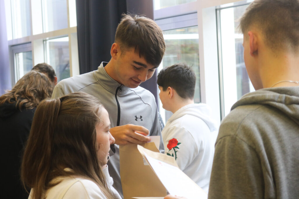 students celebrating A level results in the hall