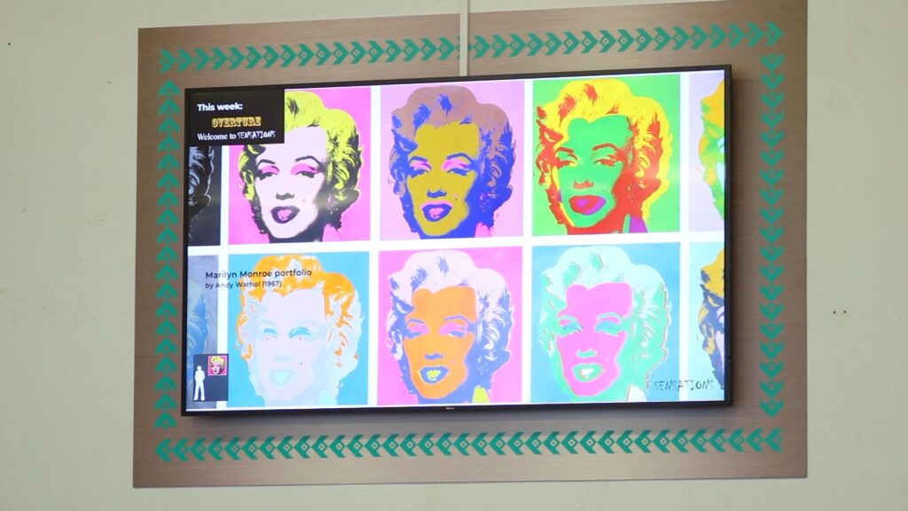a painting of Marilyn Monroe on a tv in a classroom